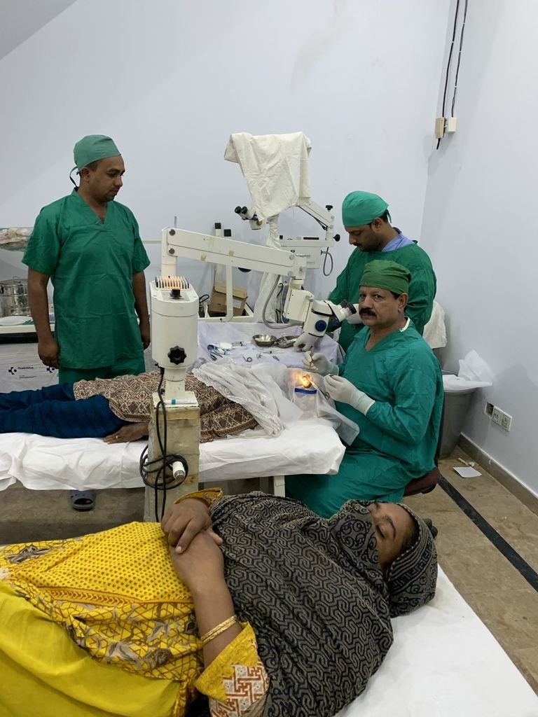 Surgeons operating while the next patient rests nearby
