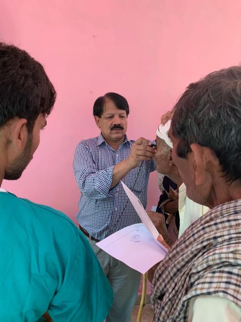 A doctor checks a patient’s eyes with a torch