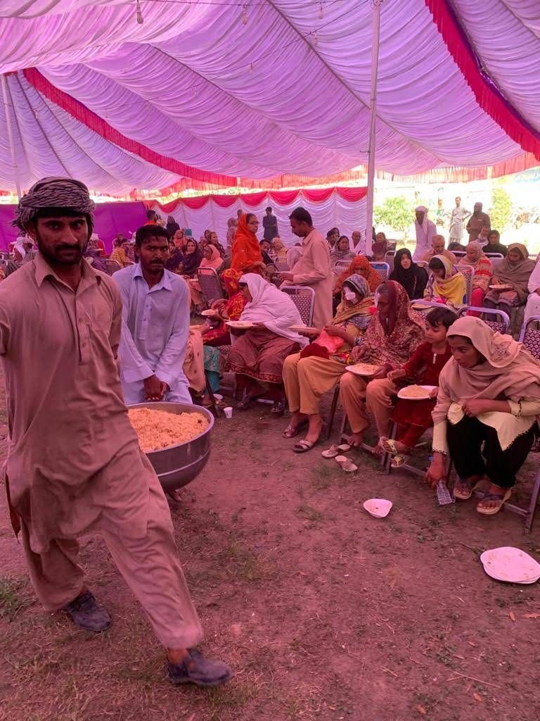 A volunteer carries a tray of food through the waiting area