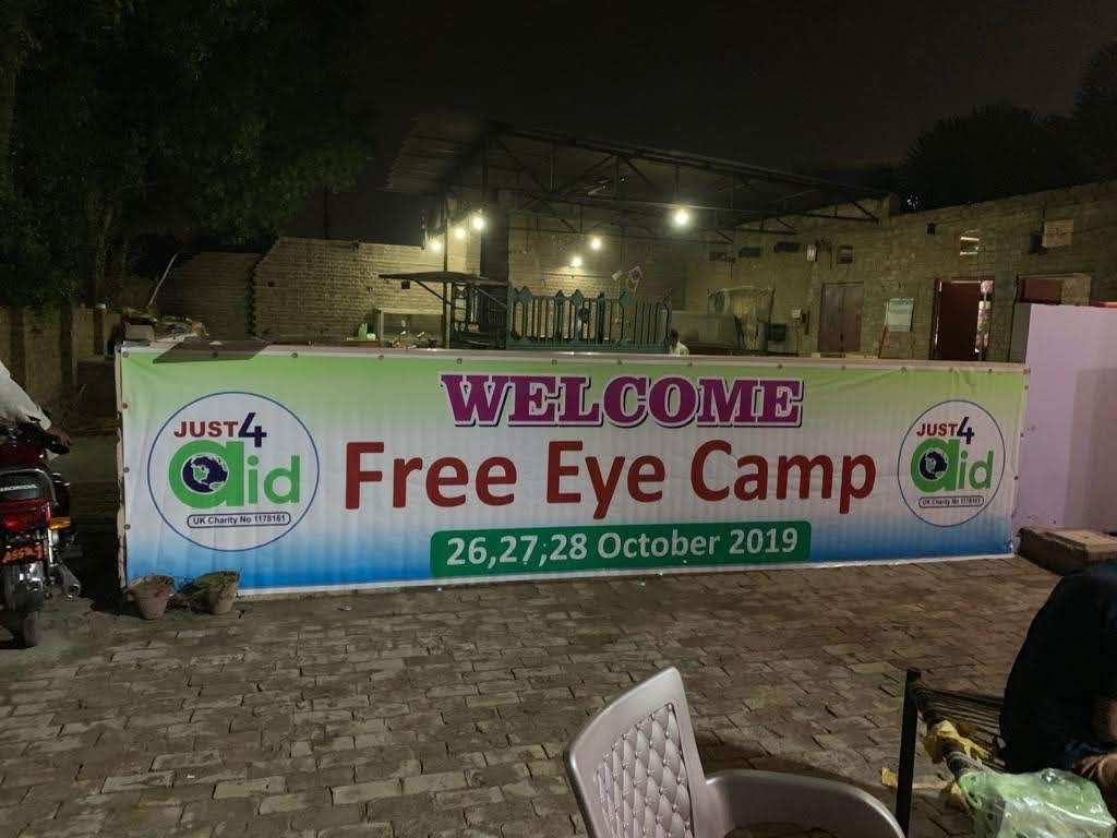 The illuminated Welcome — Free Eye Camp, 26, 27, 28 October 2019 banner at the camp entrance at night